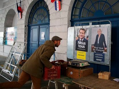 Un hombre coloca cajas de verduras delante de carteles electorales, este sábado en el mercado de Salies de Bearn, en el suroeste de Francia.