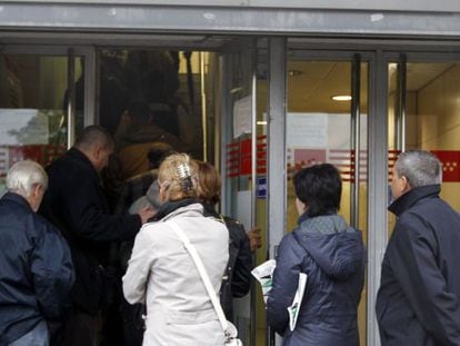 Ciudadanos hacen cola ante la oficina de empleo de un barrio de Madrid.