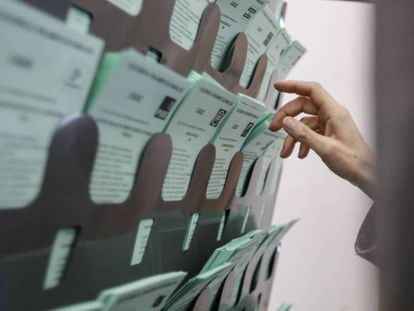 Una votante escoge la papeleta para emitir su voto, este domingo en Sanlúcar de Barrameda (Cádiz). En vídeo, Juan Marín ejerce su derecho al voto en la biblioteca municipal de Sanlúcar.