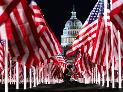 Una persona pasa entre las 200.000 banderas instaladas frente al Capitolio, un día antes de que Joe Biden jurara como nuevo presidente de Estados Unidos.