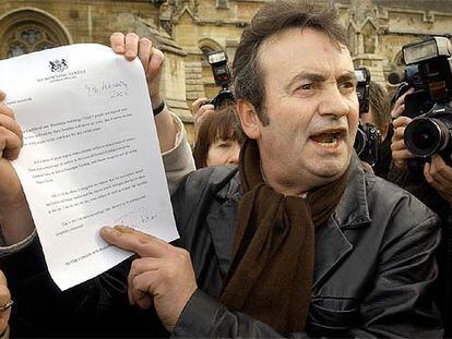 Gerry Conlon muestra la carta de disculpa de Tony Blair frente al Parlamento británico.