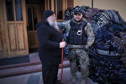 El padre Makarios y Stas, uno de los civiles armados que viven estos días en el monasterio de San Teodosio de Kiev.