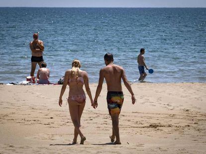 Una pareja camina por la playa, en una imagen de archivo.