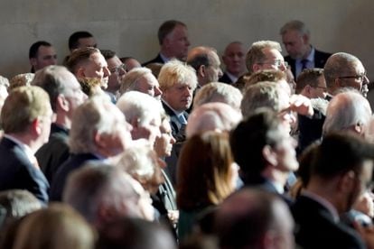 El ex primer ministro Boris Johnson (centro) escucha al presidente ucranio quien se dirige a los parlamentarios en la Abadía de Westminster. 