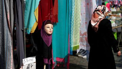 Una mujer con velo islámico pasa por delante de una tienda que vende hiyabs en el barrio bruselense de Molenbeek.