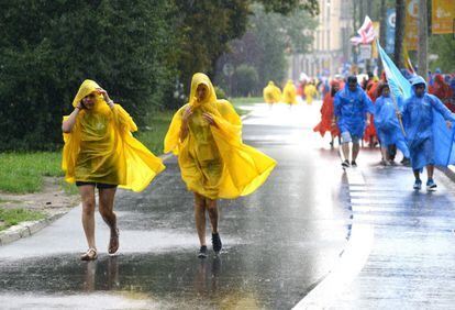 Peregrinos corren bajo la lluvia durante la primera jornada de las JMJ 2016, el día 26 de julio, en Cracovia, Polonia.