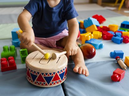 Un bebé juega con un tambor.