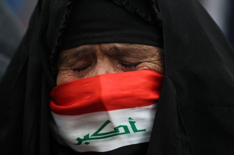 Una anciana con el rostro cubierto con una bandera nacional llora durante una protesta en la plaza Tahrir de Bagdad (Irak), el 10 de enero.