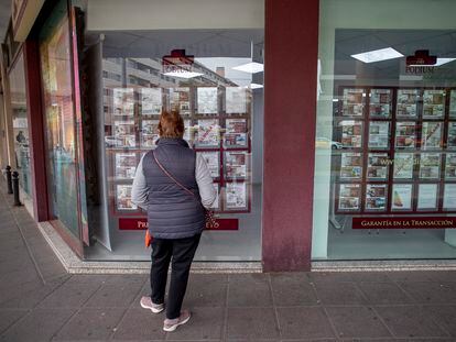 Una mujer mira los anuncios de compra venta de pisos en una inmobiliaria de Sevilla.
