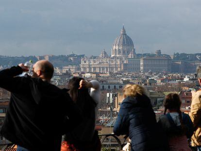 Unos turistas contemplan la basílica de San Pedro desde un parque público, este jueves en Roma.