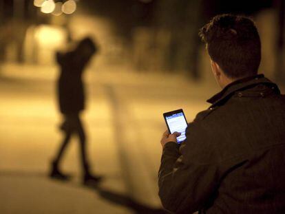 Un joven env&iacute;a mensajes con su tel&eacute;fono m&oacute;vil. 