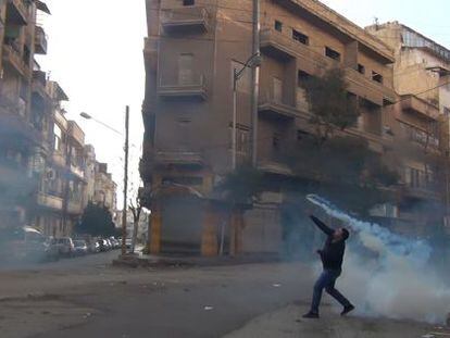 Un manifestante lanza un bote de humo a las fuerzas de seguridad.
