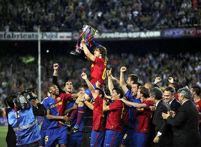 Puyol, a hombros de sus compañeros, muestra a los aficionados azulgrana el trofeo de campeón de la Liga, ganado por el Barça.