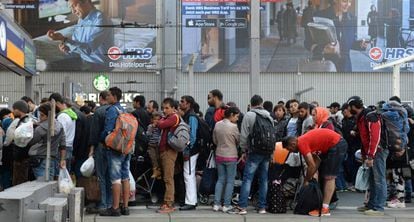 Decenas de migrantes aguardan para coger un tren en una estaci&oacute;n de M&uacute;nich (Alemania), en septiembre de 2015. 