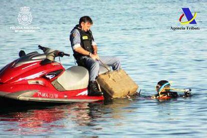 Agentes de la Policía Nacional decomisan un cargamento de hachís en aguas de la costa malagueña.