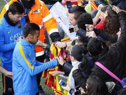 Neymar y Messi firman aut&oacute;grafos a los aficionados.