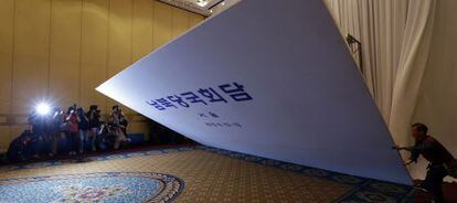 Operarios del Hilton de Seúl desmantelan un cartel en el lugar de las negociaciones.