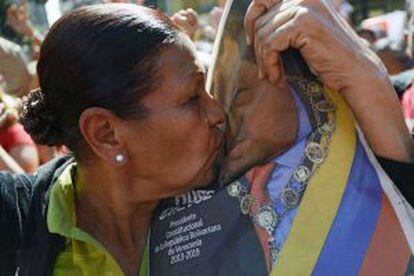 Una mujer besa una foto de Chávez, hoy en Caracas.