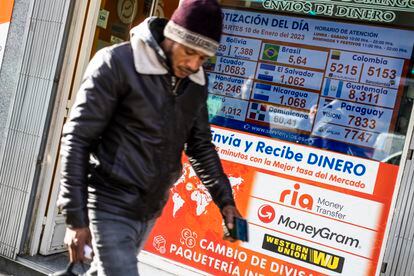 Un hombre pasa delante de una tienda para cambio y envío de dinero.