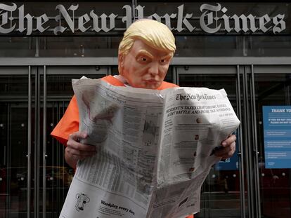 El activista Mike Hisey, disfrazado como Trump vestido con un traje de prisión leyendo el 'Times' frente a la puerta del diario neoyorquino, este lunes.