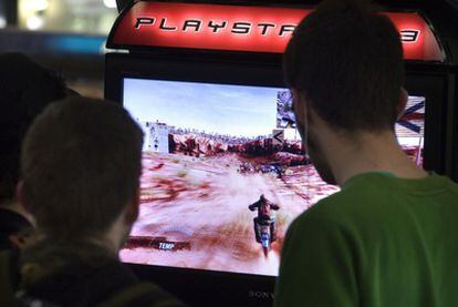 Dos jóvenes juegan con una Playstation.