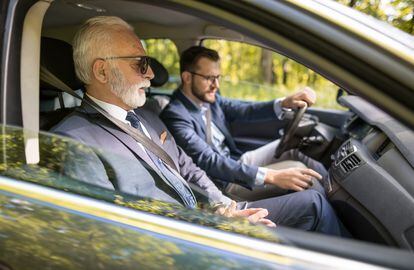 Dos ejecutivos viajan juntos en automóvil a una reunión de negocios.