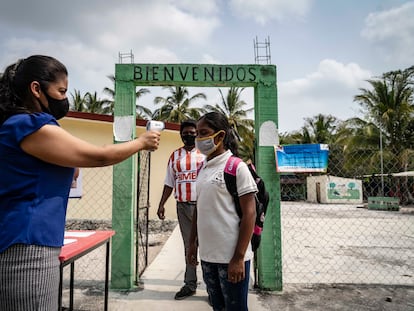 Aracely Muñoz toma la temperatura de Rubisela Hernández, alumna de la escuela Venustiano Carranza, ubicada en el municipio de Champotón, Campeche.