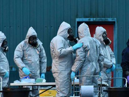 Policías británicos protegidos con trajes especiales trabajan en el lugar donde fue atacado Sergei Skripal. 