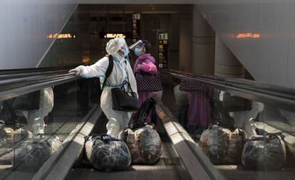 Dues dones arribant aquest diumenge a la terminal 1 del Prat, a Barcelona.