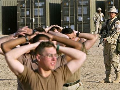 Una <i>marine</i> de EE UU vigila a un grupo de falsos prisioneros de guerra durante un ejercicio a 32 kilómetros de la frontera de Irak.