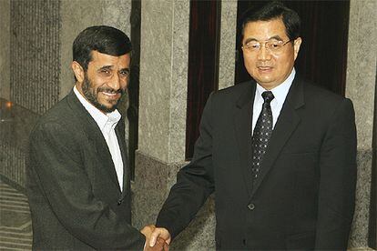 El presidente iraní, Mahmud Ahmadineyad, saluda al presidente chino, Hu Jintao, ayer en Shanghai.