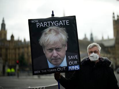 Un manifestante sostiene una pancarta con una imagen del primer ministro británico en la que pide su destitución por el 'partygate'.