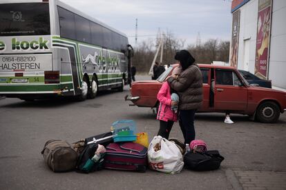 Natasha Sarkisiyan and her daughter cry as they wait with their suitcases and their birdcage for a bus to be evacuated from Kramatorsk.