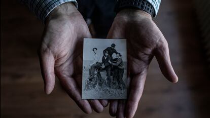 Agustín Molleda, 72, sujeta una imagen en la que se le puede ver a él (primero por la derecha) junto con otros compañeros de San Cayetano. Gijón, Asturias. Diciembre 21, 2021. (Manu Brabo)