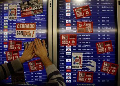 Un sindicalista pega carteles en el aeropuerto de Barajas, durante la huelga general