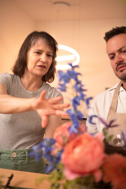 Bustamante helps one of the students in the floral composition course. 