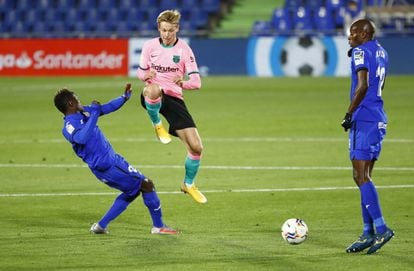 De Jong, del Barça, salta e intenta controlar el balón entre dos jugadores del Getafe