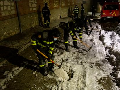 Militares de la UME rompen con ayuda de picos la capa de hielo formada en una calle de Loeches.