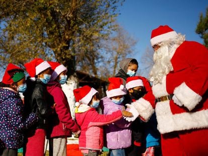 Un hombre vestido de Santa Claus entrega regalos a un grupo de niños en Ciudad Juárez, México, este 24 de diciembre.