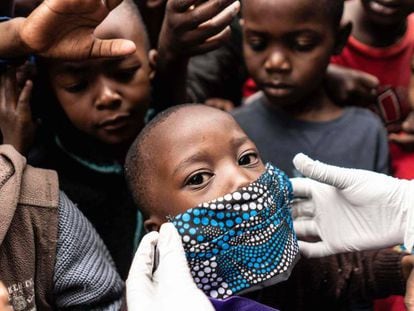 Un grupo de niños se agolpa para el reparto de comida en Nairobi (Kenia).