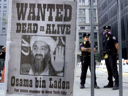 Dos policías al lado de un cartel repartido por un diario de Nueva York el 18 de septiembre de 2001, que pedía la captura de Osama Bin Laden, con el lema: "Se busca vivo o muerto".