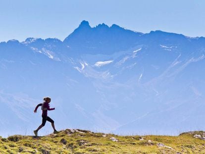 Una mujer corre con las montañas de fondo en el parque natural de Chartreuse, en Francia.