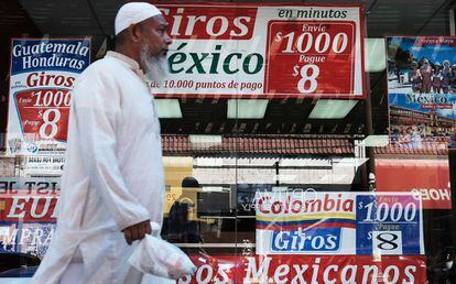 Un hombre camina delante de una tienda especializada en viajes y envío de dinero a Latinoamérica.