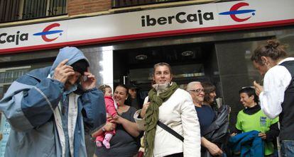 Residentes de la Corrala La Utop&iacute;a salen de la sucursal de Ibercaja en el barrio de Los Remedios, en Sevilla.