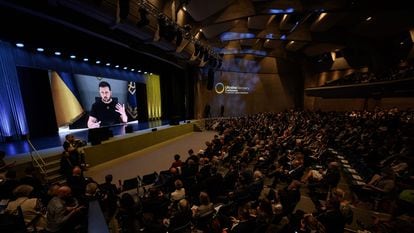 El presidente ucranio, Volodímir Zelenski, en una pantalla gigante durante la conferencia, este lunes en la ciudad suiza de Lugano.