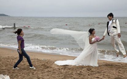 Una pareja de reci&eacute;n casados durante una sesi&oacute;n fotogr&aacute;fica en la playa de Qinhuangdao Beidaihe, al este de China.