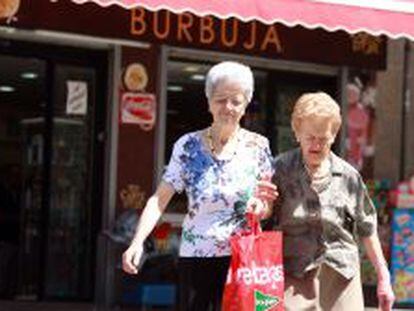 Dos mujeres mayores caminan por una calle de Madrid. 