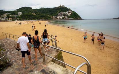 Bañistas se dirigen a la playa de Ondarreta de San Sebastián (Gipuzkoa) durante este miércoles de calor.
