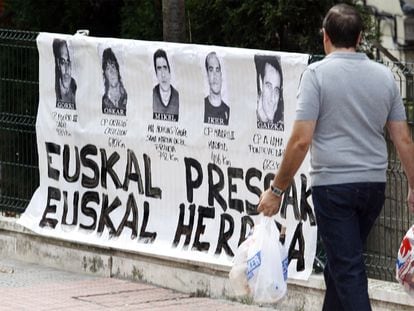Un hombre pasa frente a un cartel de presos de ETA en el barrio bilbaíno de Uribarri en una imagen de 2019.