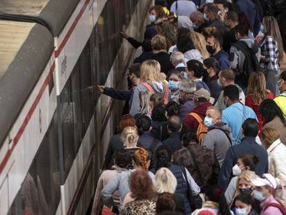 Un gran número de pasajeros intenta subir a un tren en la estación madrileña de Atocha en el primer día de huelga.
